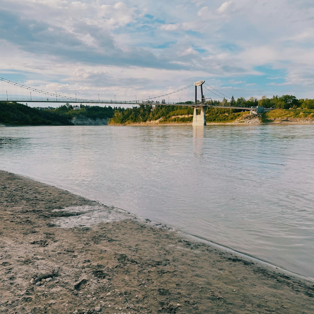 a body of water with a bridge in the background