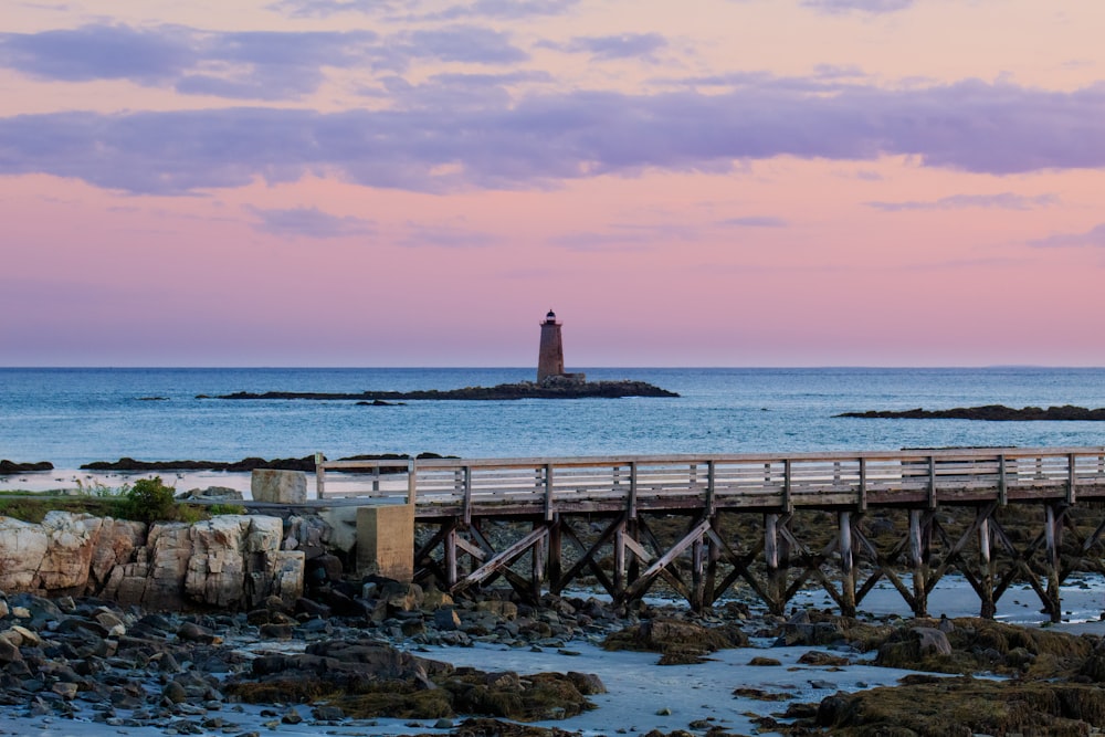 a pier with a light house in the distance