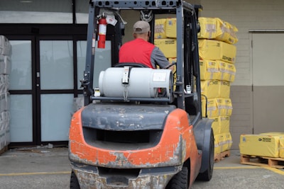 Forklift operator carefully moving heavy materials in a warehouse.
