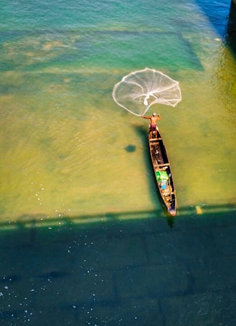 A local fisherman casting his net into the clear blue waters near Miches beach.