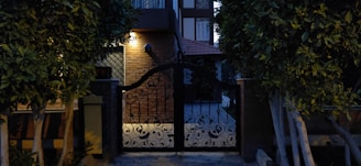 A sleek modern iron gate installed at the entrance of a stylish home during sunset.