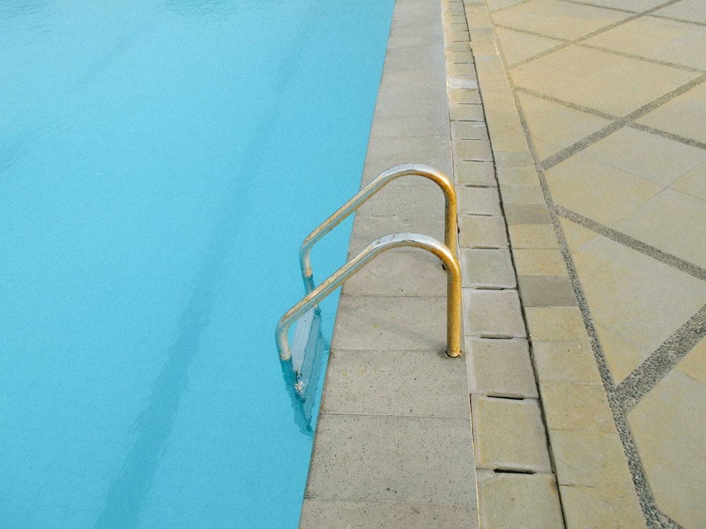 a swimming pool with a metal hand rail next to it