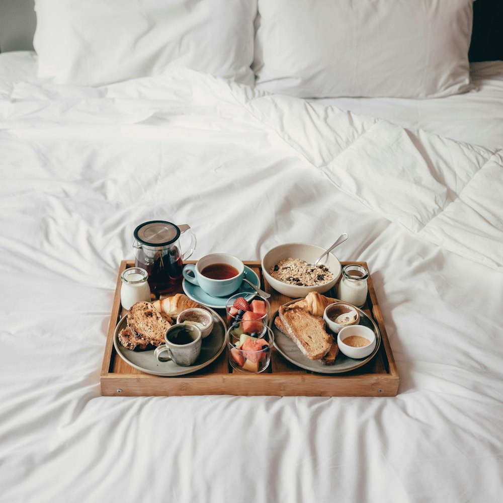 a tray of food sitting on top of a bed