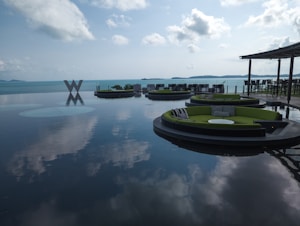 a group of green couches sitting on top of a large body of water