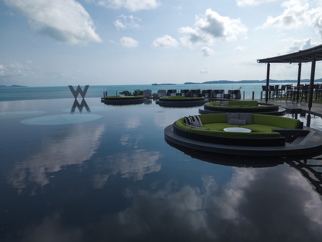 a group of green couches sitting on top of a large body of water,