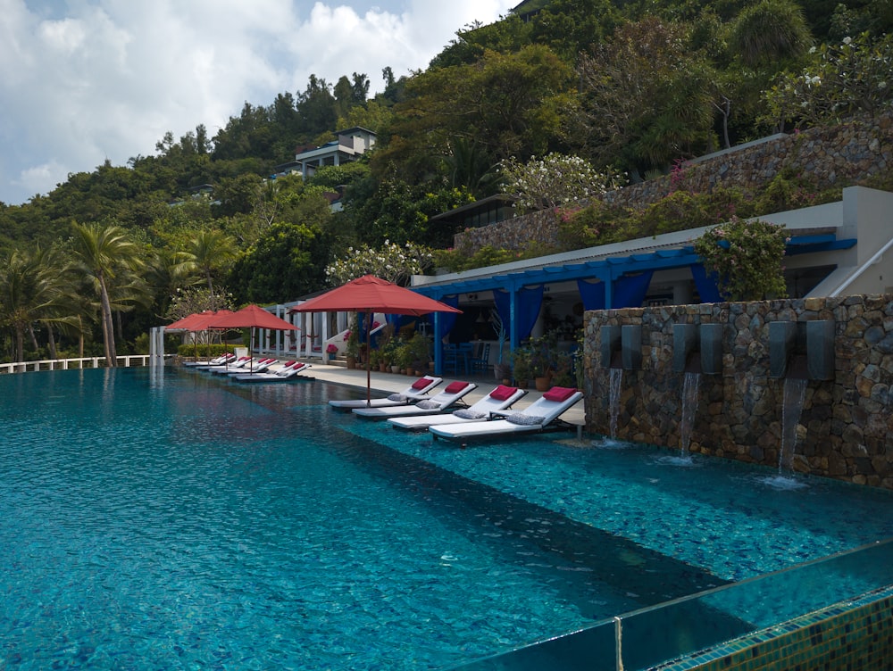 a row of lounge chairs sitting next to a swimming pool