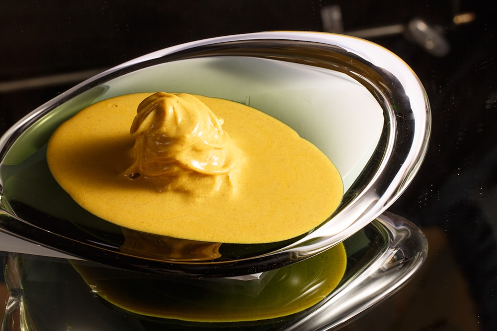 a bowl filled with yellow sauce on top of a table
