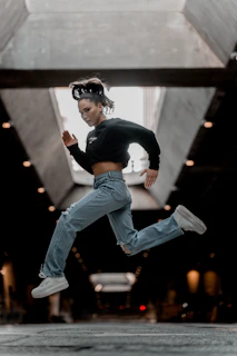 A boy jumping in mid-air wearing flexty's durable jeans and a graphic tee