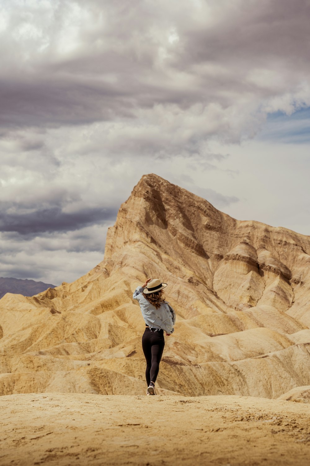 Una donna con un cappello cammina nel deserto