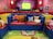 A colorful assortment of kids' shaped cushions arranged on a soft rug in a bright playroom.