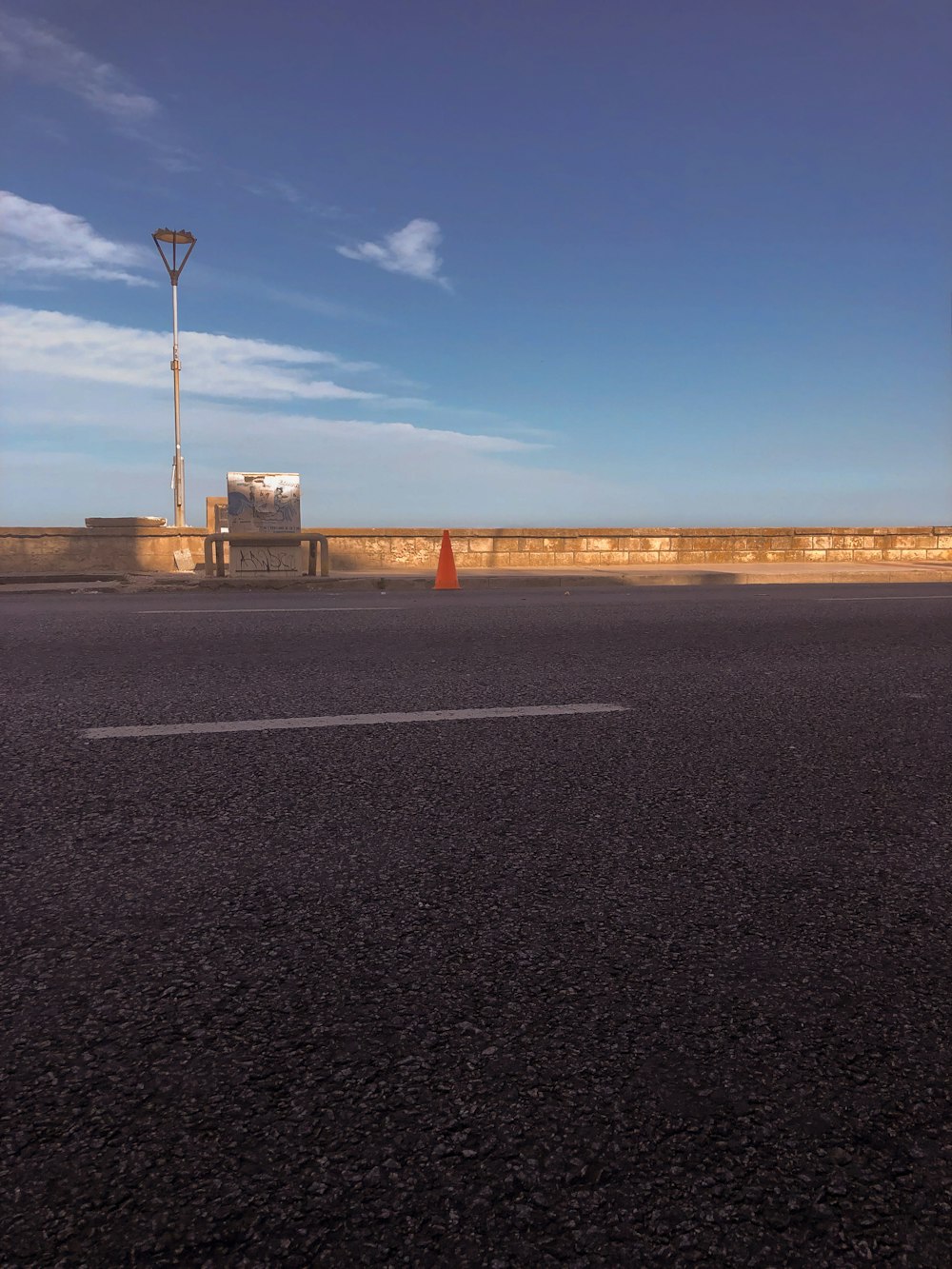 an empty parking lot with a street light in the distance