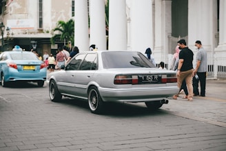 A comfortable sedan waiting outside a busy Trivandrum street for local taxi service.