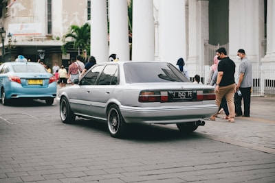 A comfortable sedan waiting outside a busy Trivandrum street for local taxi service.
