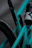 Close-up view of a teal mountain bike frame with visible branding and a mounted water bottle holder. The frame features suspension components and appears to be designed for off-road biking.