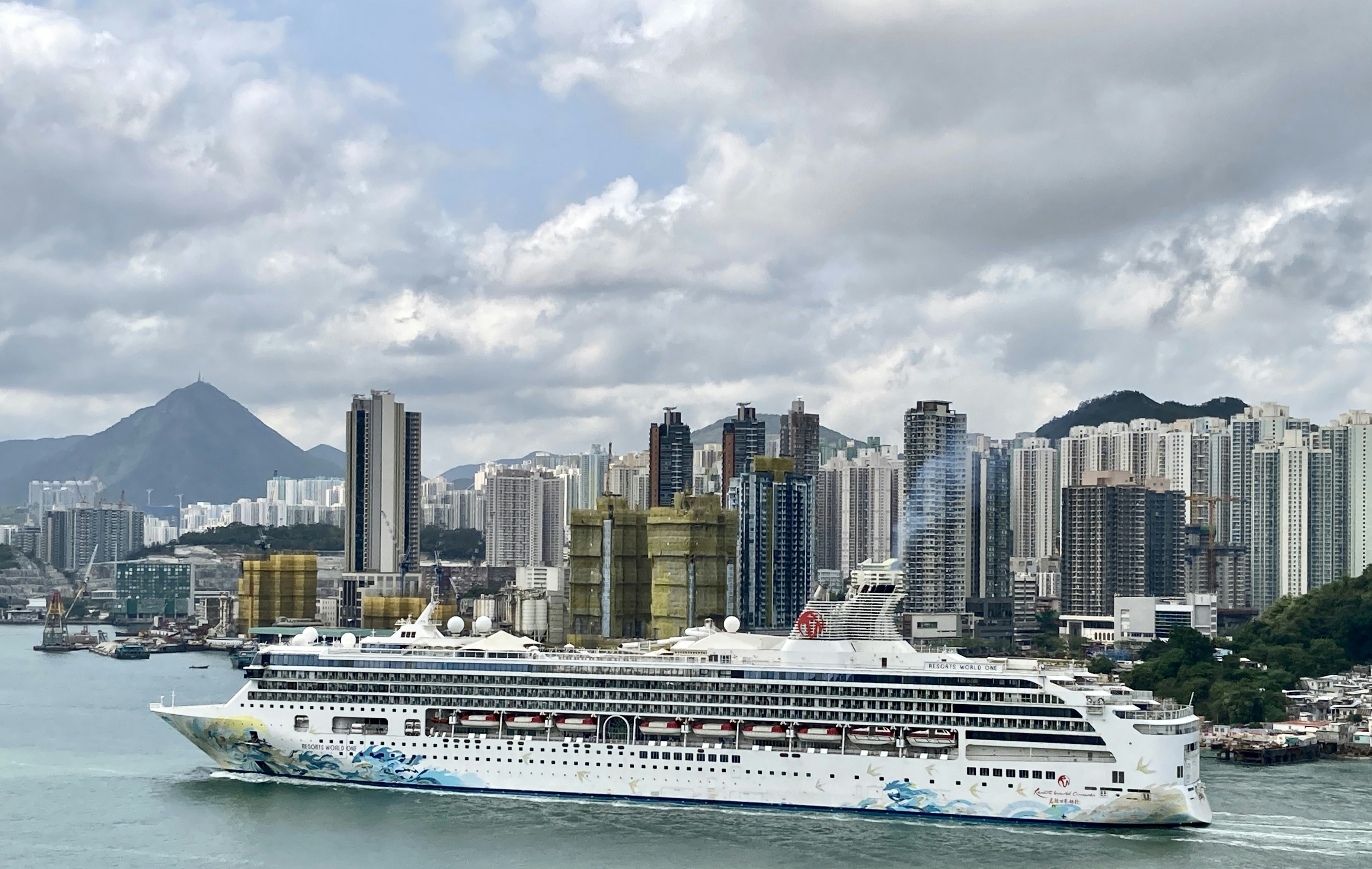 a cruise ship in the water with a city in the background