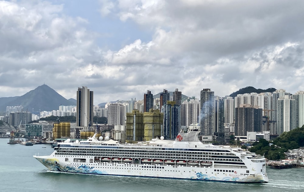 a cruise ship in the water with a city in the background