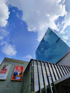 Close-up of the commercial mall’s sleek glass facade reflecting the sky.