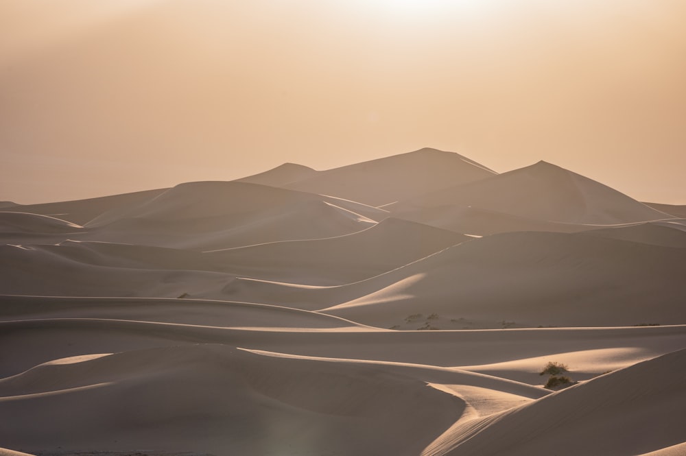 the sun is shining over the sand dunes