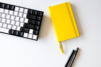 Modern office workspace with a laptop and notebook on a clean desk.