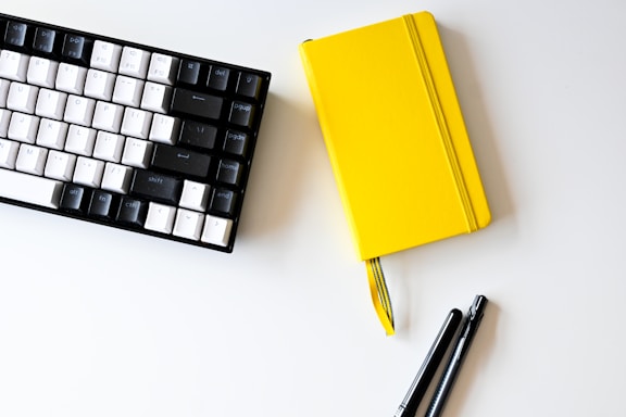 Modern office workspace with a laptop and notebook on a clean desk.