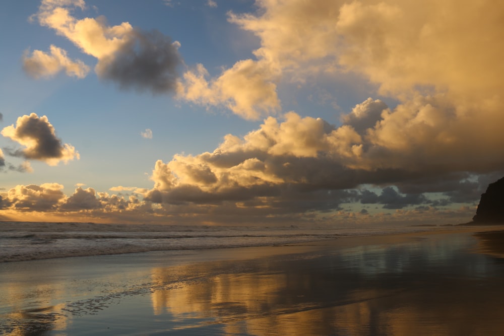 uma praia que tem algumas nuvens no céu