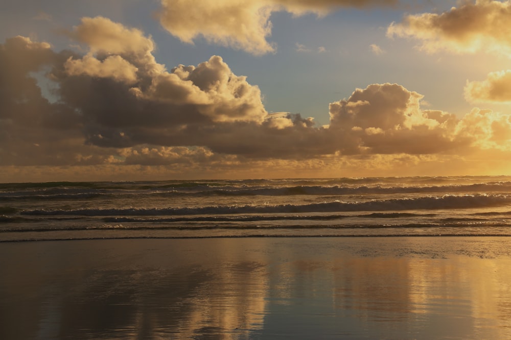 uma pessoa caminhando na praia ao pôr do sol