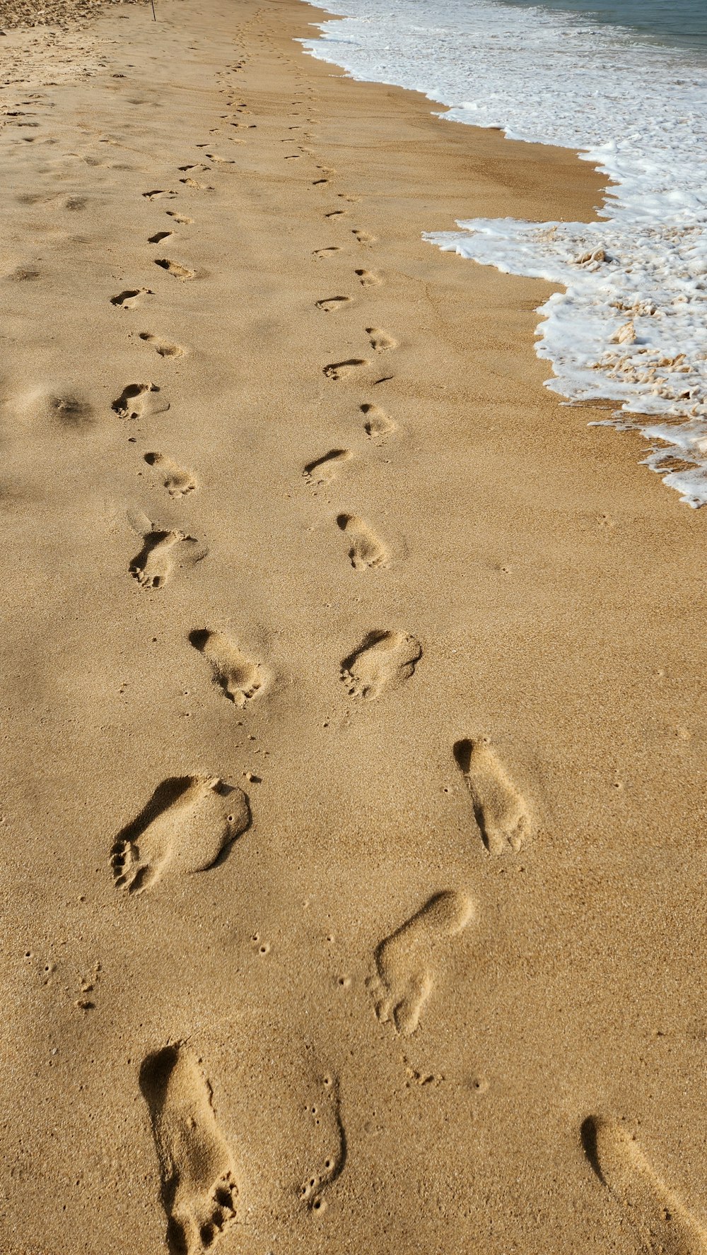 a sandy beach with footprints in the sand