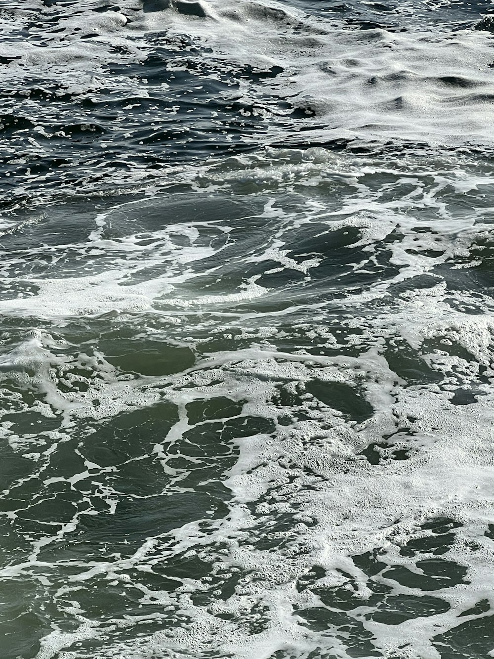 a man riding a surfboard on top of a wave covered ocean