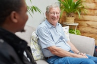 a man sitting on a couch talking to another man