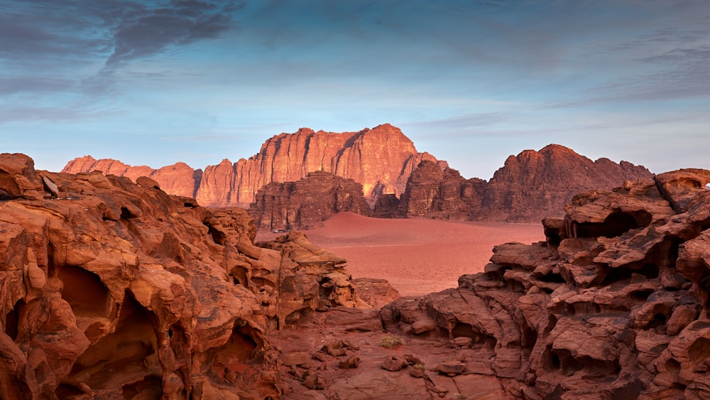 a rocky landscape with a mountain range in the background