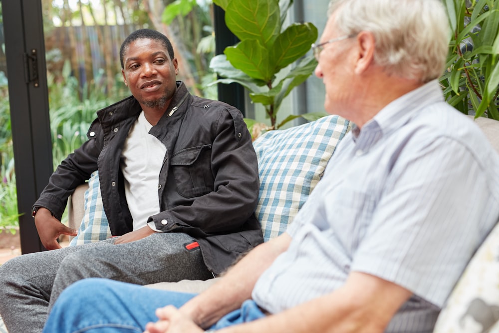 a couple of men sitting on top of a couch