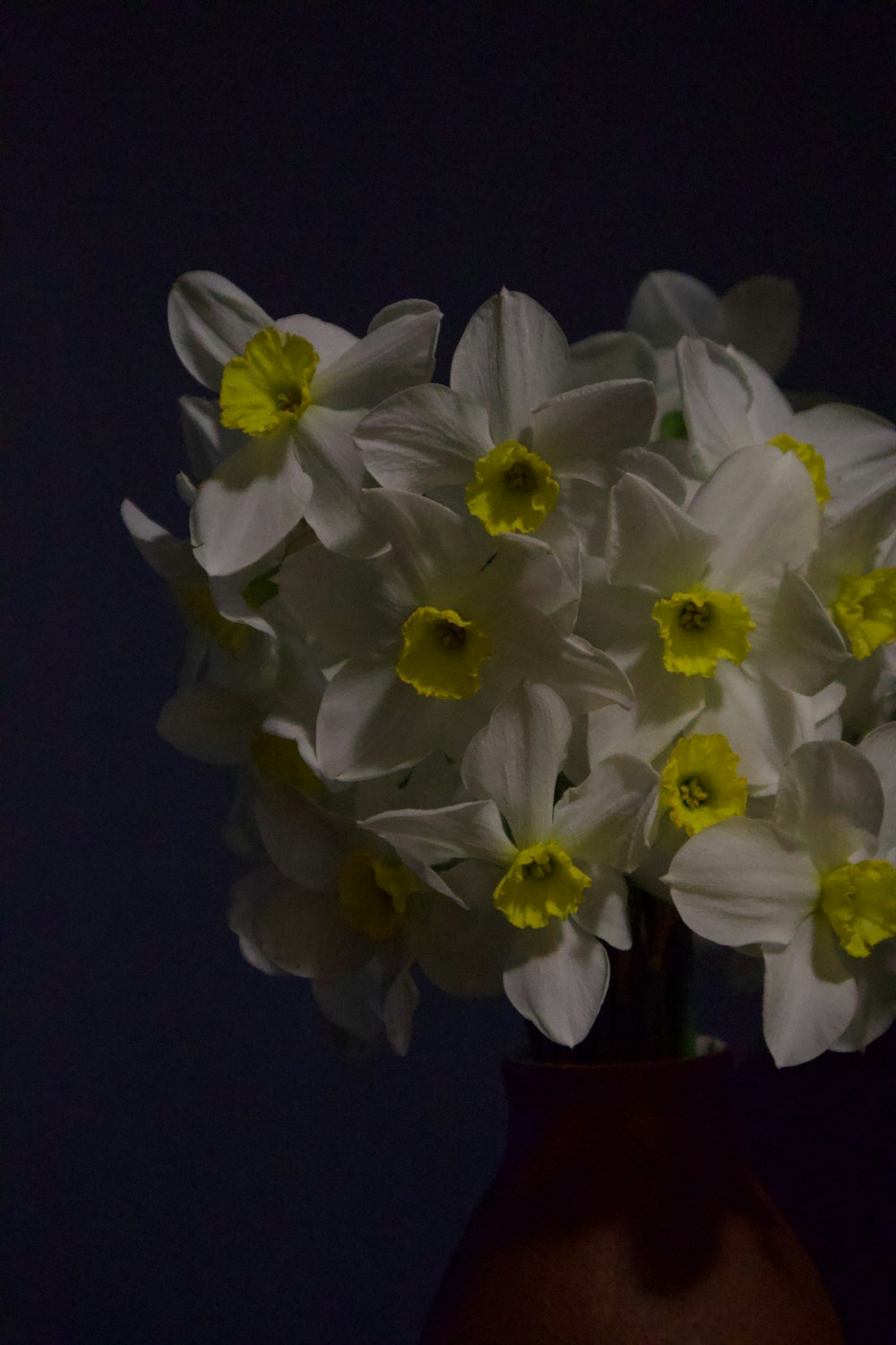 a vase filled with white and yellow flowers