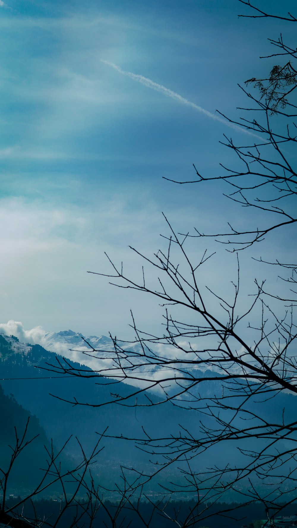 a view of a mountain with a few clouds in the sky