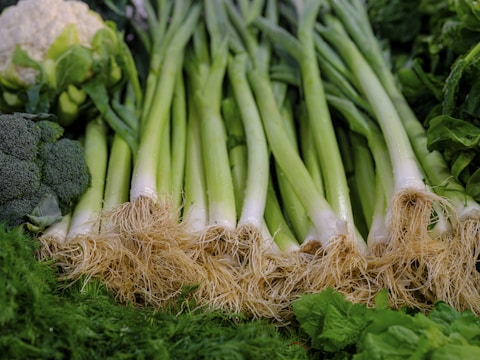 A variety of fresh onions displayed on a wooden table.