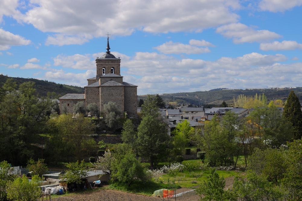 a church with a steeple surrounded by trees