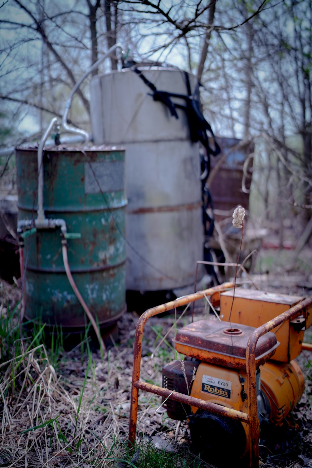 a rusted out lawn mower sitting in the middle of a forest
