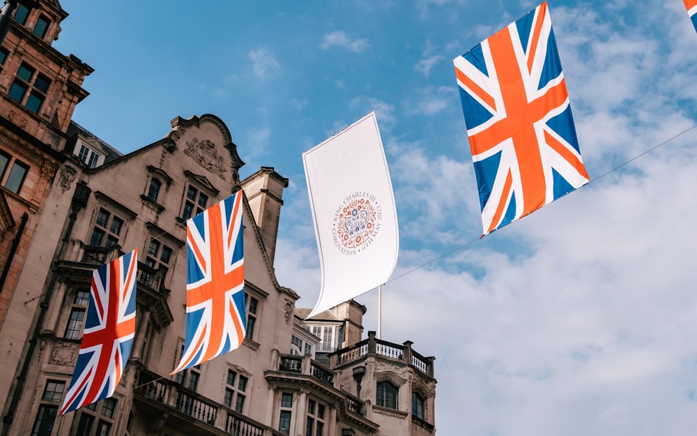 a group of flags flying in front of a building