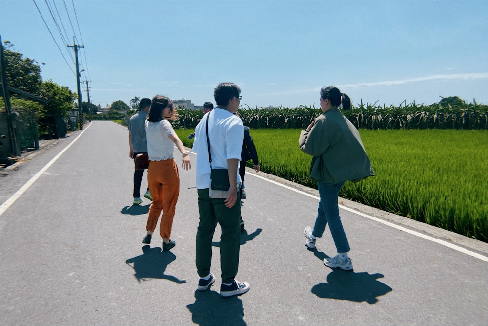 a group of people standing on the side of a road