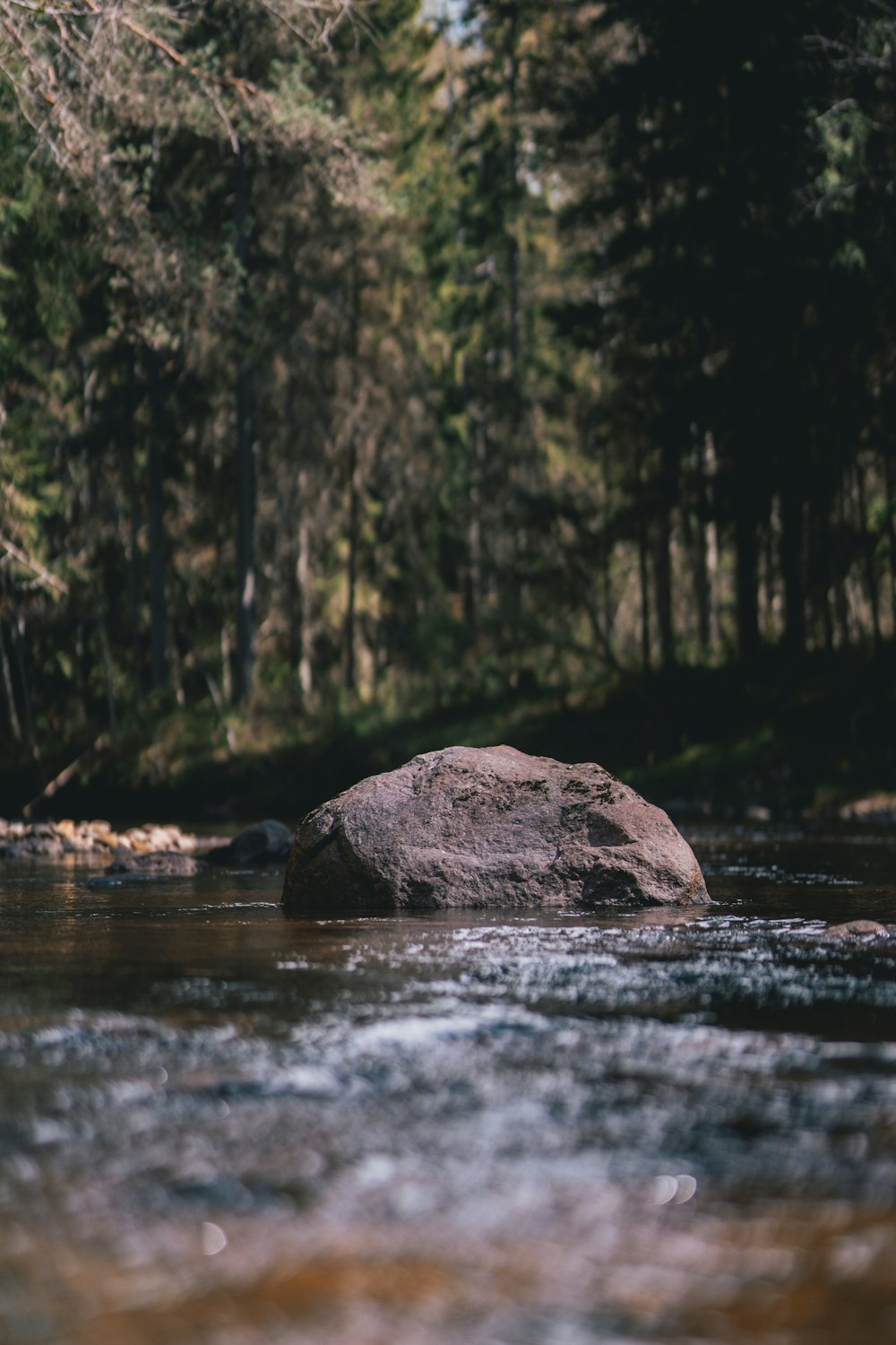 a large rock sitting in the middle of a river