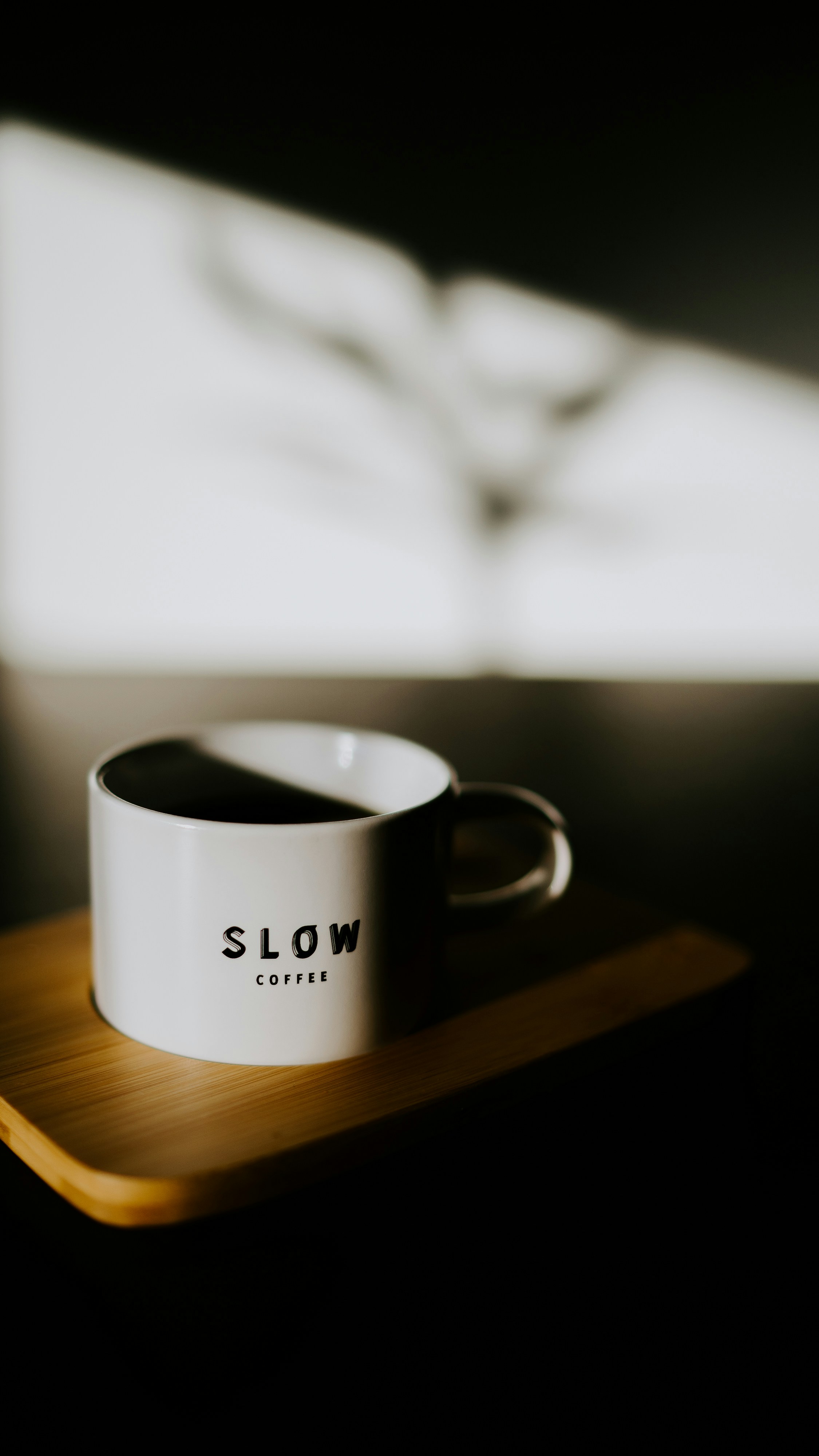 나무 쟁반 위에 놓인 하얀 커피잔