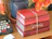 A stack of romance novels tied with a delicate ribbon on a wooden table.