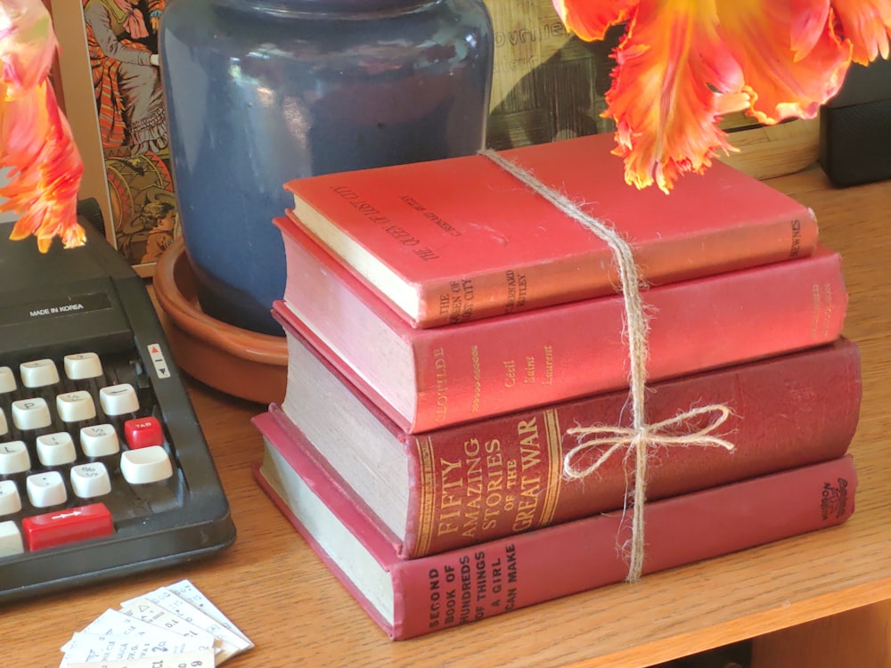 a stack of books sitting next to a calculator