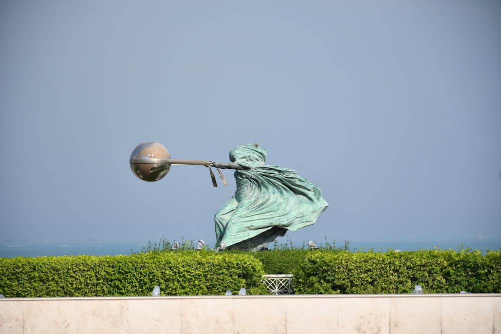 a statue of a woman holding a pole