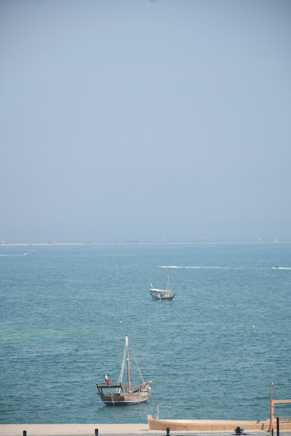 a couple of boats floating on top of a large body of water