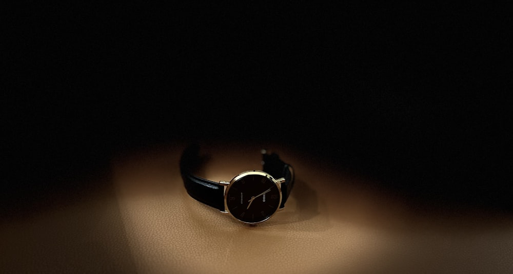 a watch sitting on top of a table in the dark