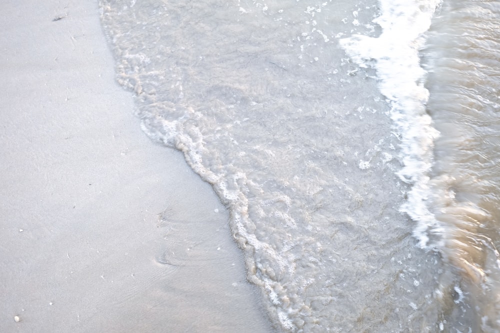 une plage avec une vague qui arrive sur le rivage
