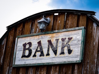 a bank sign on the side of a wooden building
