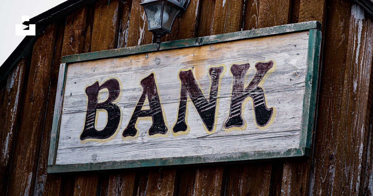 A bank sign on the side of a wooden building photo – Free Boards Image ...
