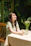 A happy woman enjoying fresh air in a bright, green-themed living room.