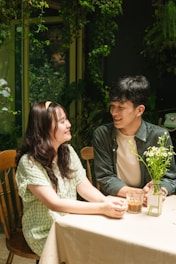 A couple sitting together, smiling and discussing their relationship in a cozy setting.